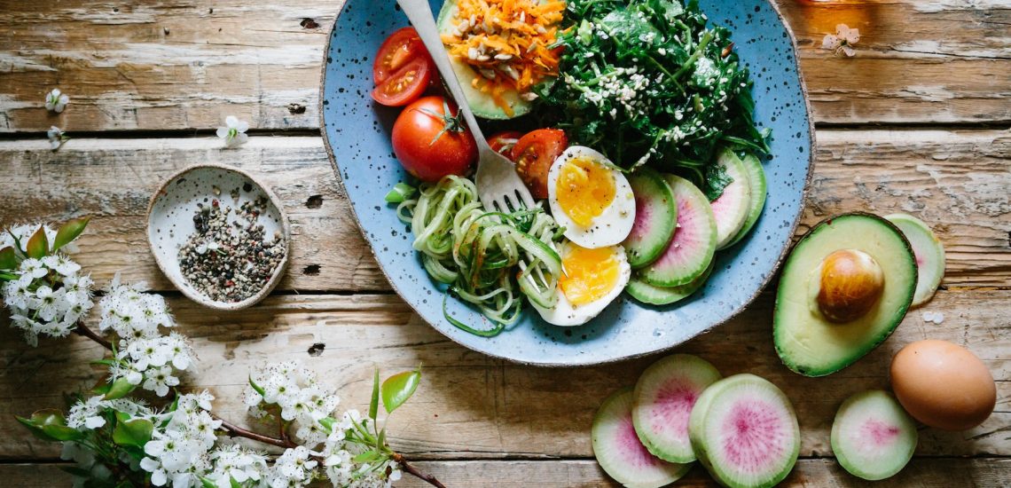 poached egg with vegetables and tomatoes on blue plate